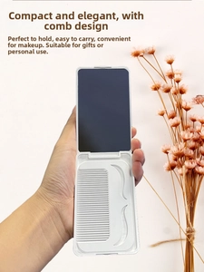 Macro detail of portable folding white makeup mirror and integrated comb in hand