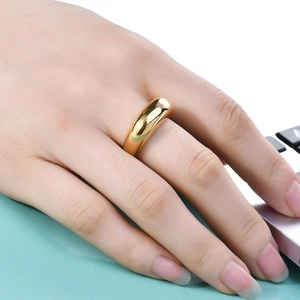 Polished 18K gold-plated teardrop ring on finger in a modern office lifestyle setting