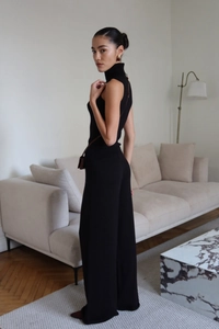 Chic black knitted high neck sleeveless top and wide leg pants set in a minimalist setting