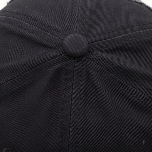Macro shot of cotton twill texture and reinforced stitching on black baseball cap top