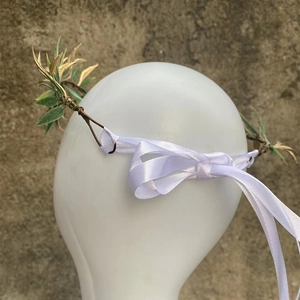 Detailed back view of a forest-style leaf headband with white ribbons and golden leaves