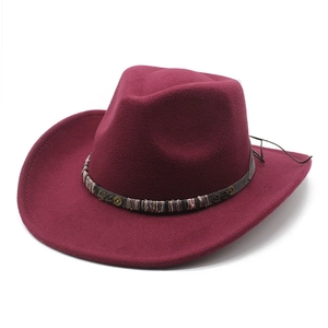 Detail of dark red felt cowboy hat featuring ethnic woven band and metal gear accents