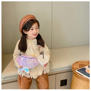 Little girl wearing a purple sequin mermaid waist bag with a knit cardigan and beret