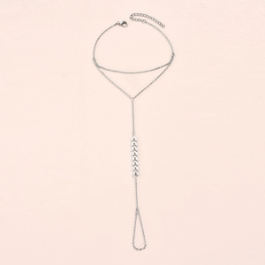 Detail of silver chain finger bracelet with leaf charms and lobster clasp closure