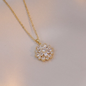 Gold sunflower necklace with sparkling zircon crystals on elegant white satin fabric