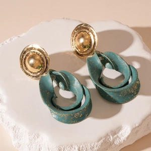 Detail view of retro geometric earrings with dark green resin and gold foil dots