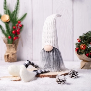 Close-up of a Christmas gnome decoration with a white knit hat and black white plaid legs