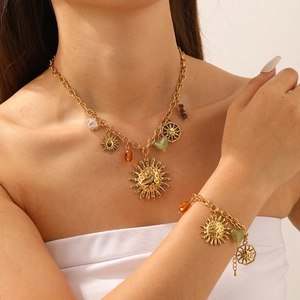 Close-up of golden sun charms and colorful tiger eye beads on chunky necklace and bracelet set
