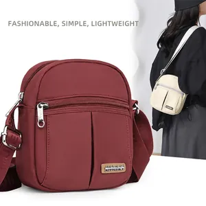 Chic multi-zipper nylon crossbody bag with wide printed strap and wine red finish