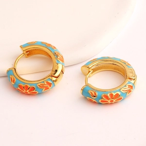 Golden round hoop earrings with blue enamel and orange floral patterns in bright light