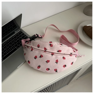 Detail of pink corduroy shoulder bag with strawberry patterns and adjustable strap