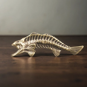 Detailed close-up of a vintage brass fish bone keychain with realistic skeletal texture