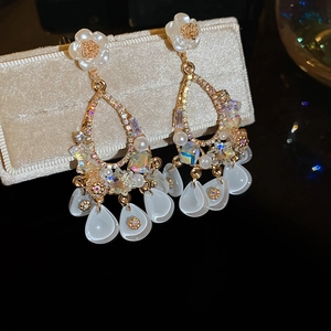 Detailed macro view of luxurious flower earrings with crystals and hanging pendants