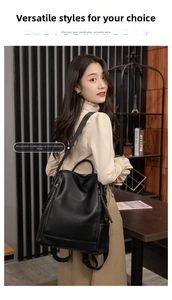 Detail of black leather backpack featuring a detachable strap for shoulder or back carry