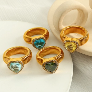 Set of four gold rings with heart-shaped colorful gemstones and twisted metal bands