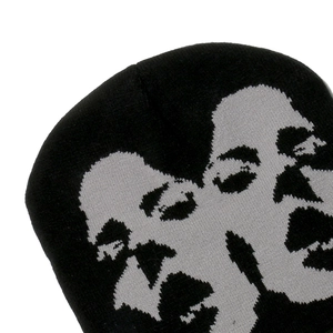 Close-up of black knit beanie featuring a grey abstract face jacquard and thick texture