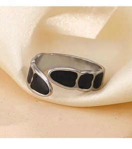 Detail of minimalist 18K gold plated stainless steel ring with black enamel drip design