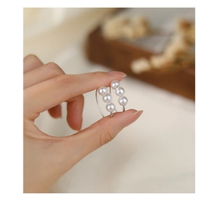 Close-up of elegant S925 silver earrings featuring three vertical white pearls on a hook
