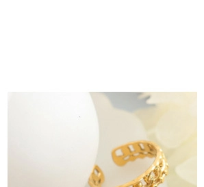 Macro detail of a golden adjustable ring featuring hollow chain link patterns and texture