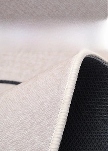 Detail of round rug showing cream short pile surface and non-slip rubber backing