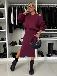 Close-up of wine red knit set featuring off-shoulder sweatshirt and side slit midi skirt