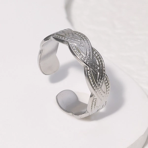 Macro view of adjustable silver ring with intricate woven texture and metallic finish