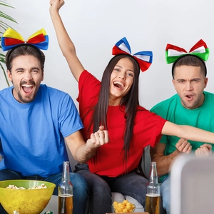 Three fans wearing colorful national flag bow headbands for world soccer tournament events