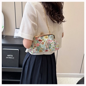 Detailansicht der bestickten Blumen-Clip-Tasche, getragen von einem asiatischen Model