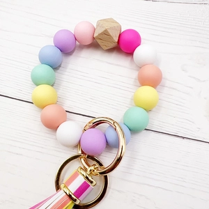 Macro detail of macabre silicone beads keychain with wooden bead and colorful tassel charm