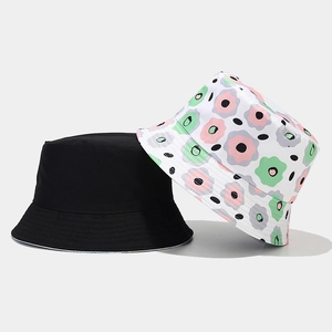 Close-up of double-sided bucket hat featuring floral pattern and solid black cotton fabric