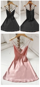 Detail of elegant satin slip dress featuring cross back straps and cowl neck design