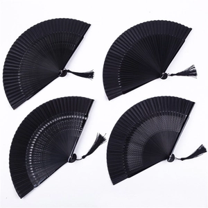 Elegant all-black Chinese folding fan set with intricate hollow patterns and silk tassels
