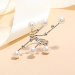 Detailed view of silver spiral ring with white pearls and branch structure on silk background