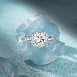 Macro shot of silver heart halo ring with pavé diamonds on blue mineral stone