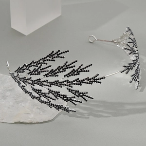 Détail d'un serre-tête de mariée en cristal noir en forme de feuilles sur fond gris
