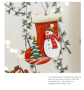 Detailed view of a wooden Christmas stocking ornament with snowman and tree on a pine branch