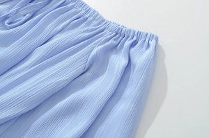 Détail du tissu bleu clair froncé avec taille élastique et texture plissée