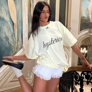 Dettaglio degli shorts in pizzo bianco a balze e t-shirt oversize indossati dalla modella