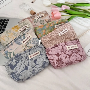Close-up of assorted floral embossed makeup bags in pastel colors with jacquard fabric