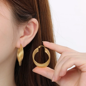 Fashionable 18k gold plated stainless steel twisted hoop earrings on female model