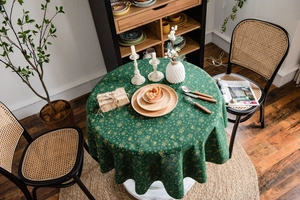 Detail of dark green tablecloth with gold snowflake patterns on a round table