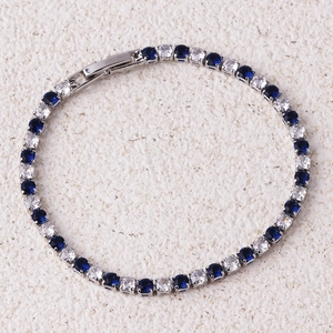 Close-up of blue and white zircon tennis bracelet with silver prong setting