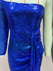 Dettaglio dell'abito con paillettes blu reale con design monospalla e vita arricciata