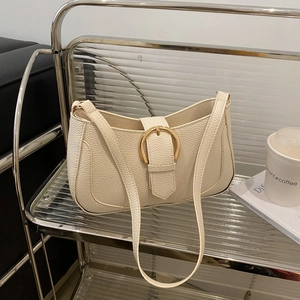 Detail of off-white lychee texture shoulder bag with gold metal buckle on a cart