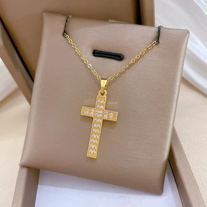 Macro shot of gold cross necklace with shimmering cubic zirconia in a jewelry gift box
