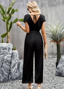 Back view of a black V-neck short sleeve jumpsuit with elegant waist tie and wide legs
