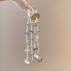 Bohemian seashell tassel earrings with white beads and gold ear hooks for beach vacations