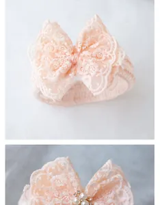 Detail of pink lace baby headband featuring satin bow with pearl and rhinestone accents