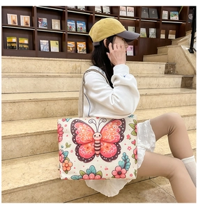 Canvas tote bag with colorful butterfly floral print shown in a lifestyle casual setting