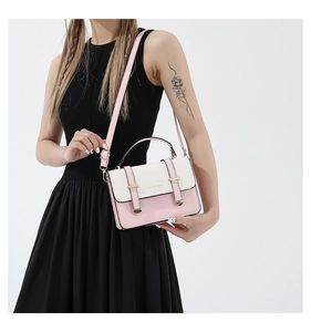 Close-up of pink and white contrast PU leather handbag with gold buckle and top handle